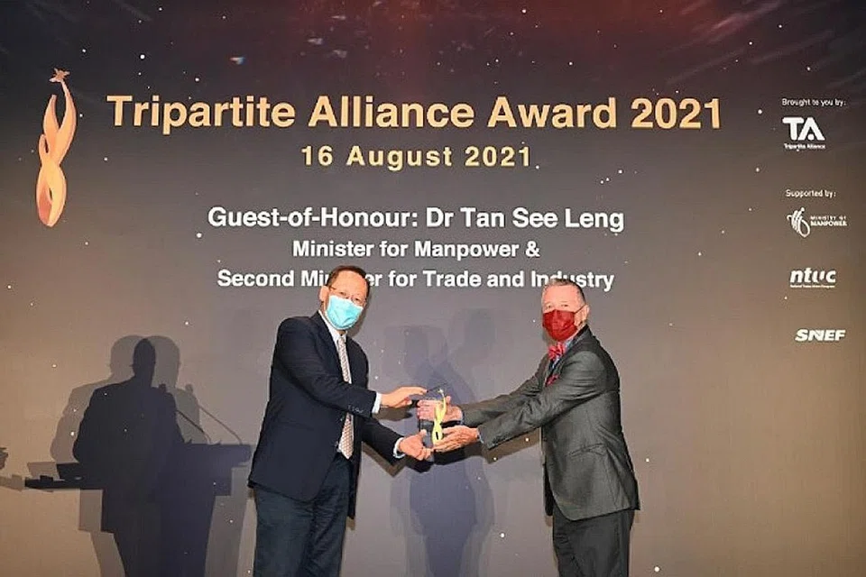 KECEMERLANGAN: Dr Tan See Leng (kiri) telah menyampaikan anugerah kepada Encik Patrick Fiat (kanan) semasa majlis Anugerah Perikatan Tiga Pihak - Foto HOTEL ROYAL PLAZA ON SCOTTS