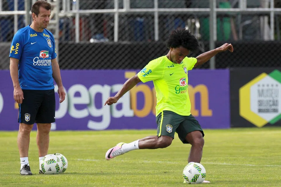 FOKUS PADA LATIHAN: Jurulatih Brazil, Dunga (kiri), dan pemainnya, Willian, semasa sesi latihan Brazil menjelang pertemuan dengan Paraguay hari ini. - Foto REUTERS