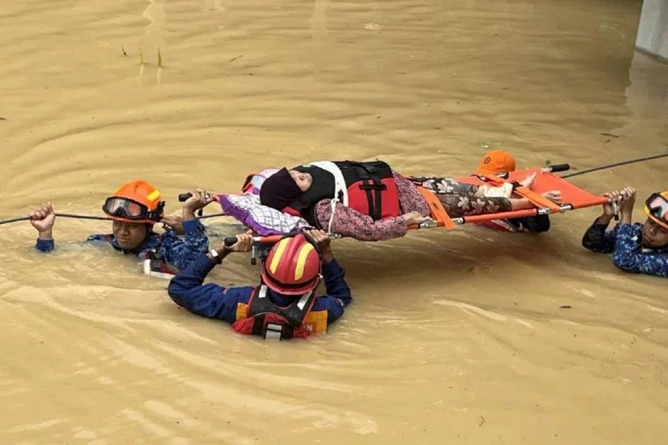 Anggota Angkatan Pertahanan Awam Malaysia (APM) Padang Terap, Kedah, mengusung mangsa banjir yang sakit ke pusat pemindahan sementara, selepas kediamannya dinaiki banjir.