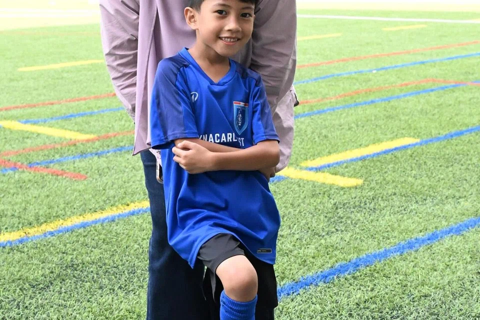 Cik Zafirah Zaibarudin bersama anaknya, Yusof Iman, tujuh tahun, yang berpeluang menimba ilmu secara langsung daripada barisan legenda bola sepak tempatan.