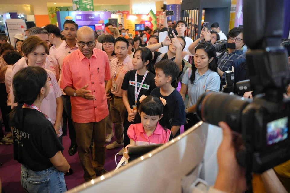 GALAK WARGA DAKAP DIGITAL: Presiden Tharman Shanmugaratnam (tengah) yang juga penaung gerakan Digital Sepanjang Hayat bersama Menteri Perhubungan dan Penerangan, Cik Josephine Teo (kiri) sewaktu Festival Digital Sepanjang Hayat yang diadakan di Heartbeat@Bedok pada Sabtu.