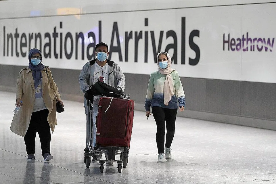 PELUANG BERCUTI: Penumpang pesawat kelihatan berjalan di balai ketibaan di Terminal 5 Lapangan Terbang Heathrow London, kelmarin sedang Britain mengumumkan langkah membuka sempadan bagi pelancong dari Amerika Syarikat dan Kesatuan Eropah yang telah menjalani vaksinasi sepenuhnya. - Foto REUTERS