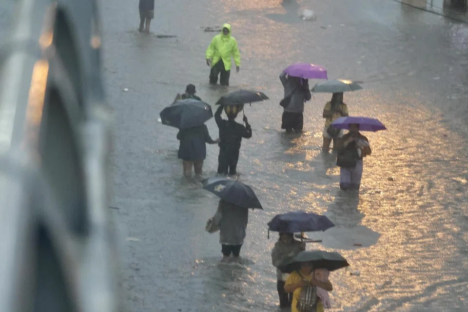 Penduduk Filipina meredah air banjir di Las Pinas, Filipina, pada 22 Julai 2025. Pada 21 Julai, biro kaji cuaca Filipina memantau dua kawasan tekanan rendah yang berpotensi berkembang menjadi taufan tropika, selepas Taufan Wipha keluar dari negara itu setelah mengorbankan sekurang-kurangnya lima nyawa.