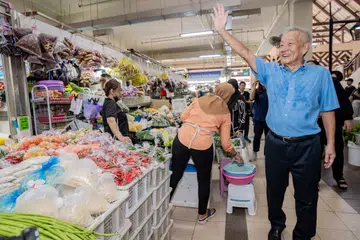BERAMAH MESRA: Bakal calon Presiden, Encik Ng Kok Song (kanan) beramah mesra dengan para pegerai dan pelanggan di Pasar dan Pusat Penjaja Geylang Serai.