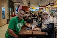 AKSES PERCUMA: Encik Mohamed Ali Matsom, 56, dan isterinya Cik Kamisah Samad, 55 merupakan antara pengunjung Our Tampines Hub (OTH) yang berpeluang mendapat akses percuma kandungan premium SPH Media dengan mengimbas kod QR berasaskan lokasi kepada mereka yang berada di OTH.