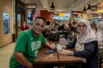 AKSES PERCUMA: Encik Mohamed Ali Matsom, 56, dan isterinya Cik Kamisah Samad, 55 merupakan antara pengunjung Our Tampines Hub (OTH) yang berpeluang mendapat akses percuma kandungan premium SPH Media dengan mengimbas kod QR berasaskan lokasi kepada mereka yang berada di OTH.