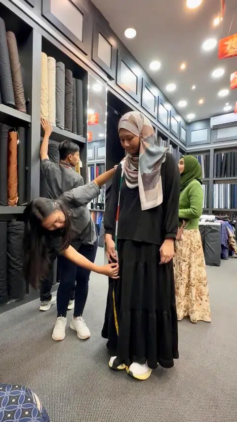Kakitangan Alla Moda Textile & Tailor mengambil ukuran untuk baju yang ditempah koresponden, Cik Nur Humaira Sajat.