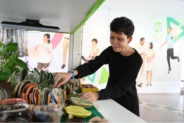 MAMPU BERDIKARI: Cik Salamah mengendalikan gerai Kelab Heal seorang diri selepas menjalani program 'Back To Work' badan tersebut. Gerai yang memaparkan produk hasil kraftangan individu yang menghadapi isu kesihatan mental itu terletak di IMH. - Foto BM oleh KHALID BABA 
