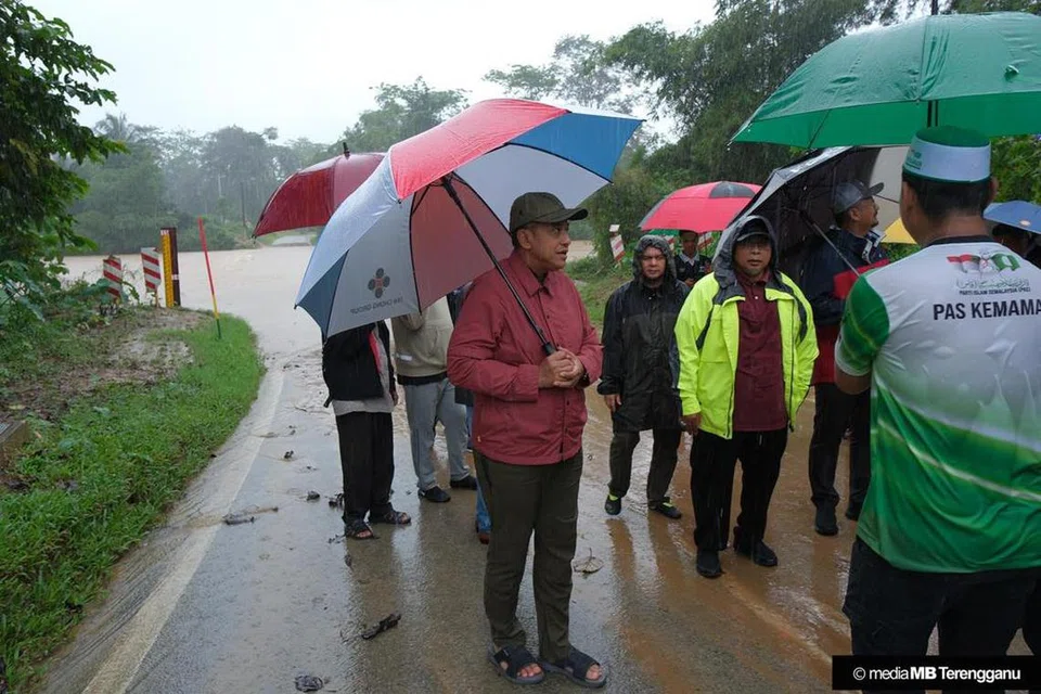 TURUN PADANG: Menteri Besar Terengganu, Datuk Seri Dr Ahmad Samsuri Mokhtar (berbaju merah), turun padang meninjau keadaan banjir di beberapa lokasi di Terengganu.