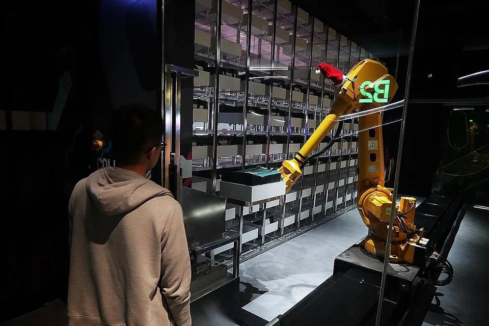 TEKNOLOGI TERKINI: Robot mengambil barangan yang dibeli pelanggan yang ditinggalkan di Funan. - Foto BH oleh KELVIN CHNG