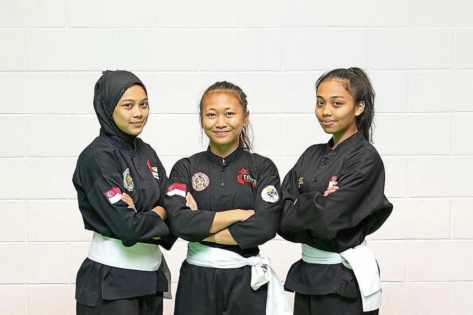 GERAK-GERI SEIRAMA: Anggota seni regu puteri (dari kiri gambar atas), Siti Nazurah, Nurzuhairah dan Nurul Syafiqah menunjukkan gerak-geri seirama semasa berlatih di Arena OCBC, Hab Sukan Singapura, sebagai persiapan menghadapi Kejohanan Pencak Silat Dunia Ke-18 yang bermula Khamis ini. Selain acara itu, Nurzuhairah juga akan turun beraksi dalam acara seni tunggal puteri. - Foto BH oleh JEREMY KWAN