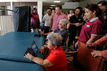 TINJAU KEADAAN: Encik Gan Kim Yong (berbaju merah) ketika melawat rumah tumpangan warga tua, Lions Home for the Elders (gambar sisipan), semalam. - Foto ZAOBAO