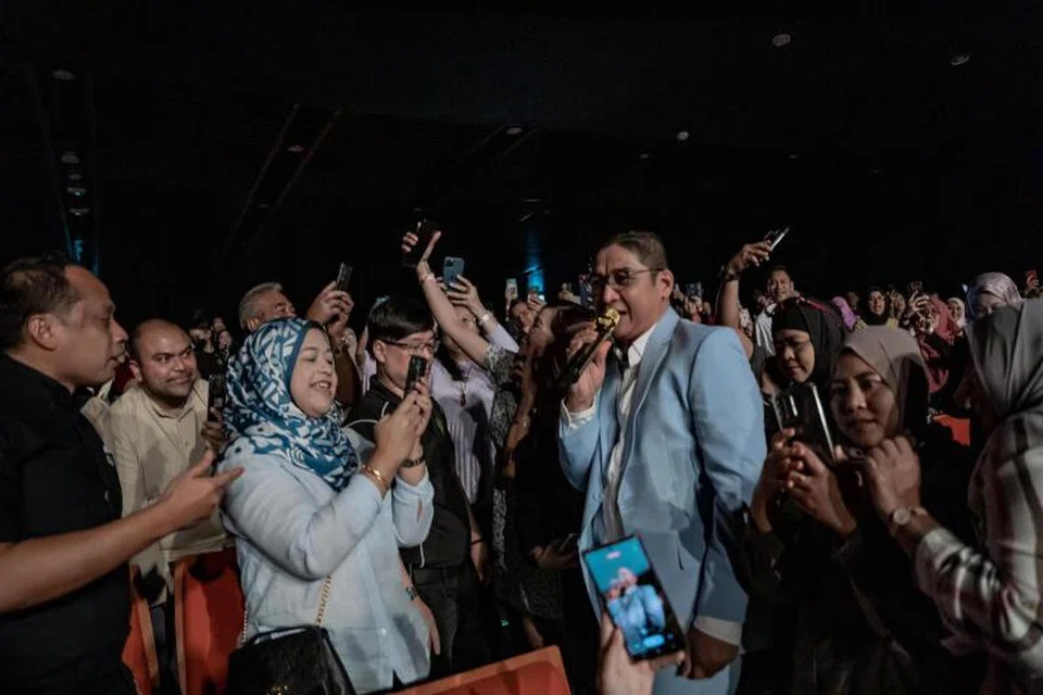 DEKATI PEMINAT: Pasha beberapa kali turun pentas bagi memenuhi permintaan peminat yang ingin bergambar dengannya sambil beliau menyanyi.