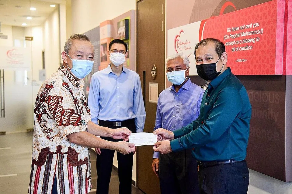 MASYARAKAT PAPAR IHSAN: CEO Kumpulan Sheng Siong, Encik Lim Hock Kee (kiri), menyampaikan cek derma $200,000 kepada CEO RLAF, Encik Muhammad Faizal Othman, sebagai sokongan kepada bantuan kemanusiaan bagi rakyat Palestin di Gaza. Turut hadir di majlis di Masjid Yusof Ishak semalam ialah Duta Tidak Bermastautin Singapura ke Penguasa Palestin dan Ghana, Encik Hawazi Daipi (belakang, kanan), dan CEO Muis, Encik Esa Masood. - Foto MUIS
