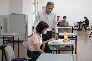 MELAWAT PENDUDUK: Menteri Ehwal Luar yang juga Ahli Parlimen GRC Holland-Bukit Timah, Dr Vivian Balakrishnan, melawat penduduk yang bermalam di bilik di Kelab Masyarakat Senja-Cashew sementara menunggu letupan bom WWII. Bilik khusus ini adalah untuk pelajar dan orang dewasa yang bekerja.