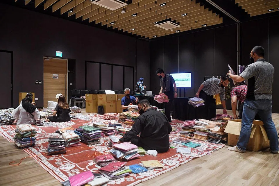 GOTONG-ROYONG: Beberapa kakitangan WGS dan sukarelawan dari pertubuhan amal termasuk Tabung Amal Aidilfitri dan Lembaga Biasiswa Kenangan Maulud turun padang untuk menjalankan projek amal ini. - Foto-foto BH oleh KUA CHEE SIONG