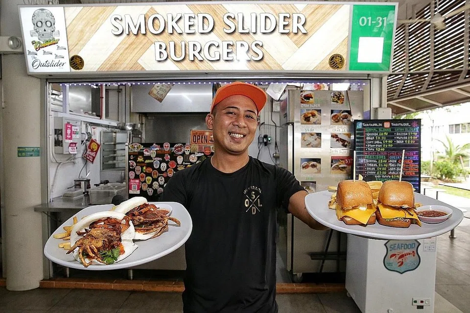 PELBAGAI BURGER/SANWIC KECIL: Cef Andri Jamil menunjukkan sajian slider ketam kulit lembut (kiri) dan slider daging lembu (kanan) di gerainya di Pusat Penjaja Taman Yishun. - Foto BM oleh KEVIN LIM
