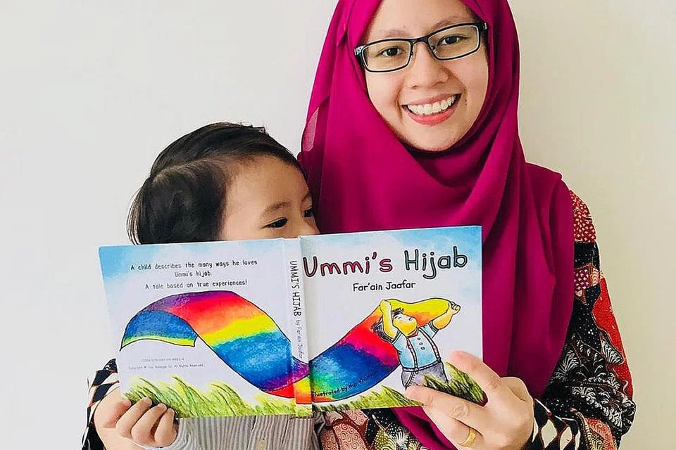 TIDAK TERFIKIR MAHU JADI PENULIS: Cik Far'ain Jaafar dan anaknya dengan buku tulisan beliau, 'Ummi's Hijab', yang kemudian diterjemahkan kepada bahasa Melayu dengan judul 'Hijab Milik Ummi'. Beliau dan rakannya mengambil keputusan mengeluarkan versi bahasa Melayu buku itu supaya kanak-kanak dapat memberikan tumpuan lebih mantap kepada bacaan mereka dalam satu bahasa. - Foto ihsan FAR'AIN JAAFAR