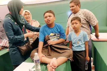 PELBAGAI RAGAM DI MAJLIS KHATAN: Muhammad Sharil (tengah) berehat setelah dikhatan, sementara adiknya, Muhammad Shawal Ramadan (depan, kanan), lega dia tidak dikhatan semalam kerana terdapat sedikit kerumitan dan akan dikhatan di hospital. Mereka ditemani bapa mereka, Encik Sabtu Abdul Hamid (belakang, kanan). - Foto JOHARI RAHMAT