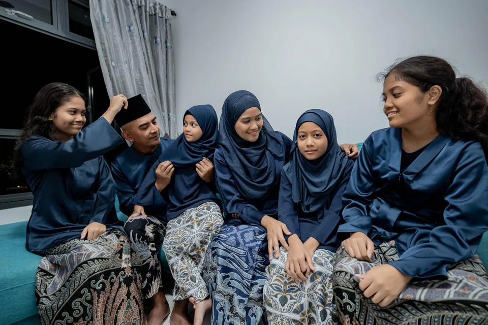 Ini merupakan kali pertama Encik Mohammad Azim Abdul Aziz (dua dari kiri) sekeluarga menyambut Hari Raya Aidilfitiri di flat HDB empat bilik Bina Ikut Tempahan (BTO) sendiri di Sengkang East. Encik Azim diapit anak-anak dan isteri (dari kiri) Ariana, Amira, Cik Nurhaileen Manje, Aurora dan Adriana.