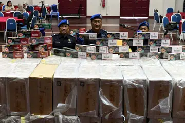 ANTARA BARANGAN DISITA: Komander Pasukan Polis Marin Wilayah Satu Pulau Pinang, ACP Shamsol Kassim (tengah), menunjukkan karton rokok yang dirampas pada sidang media di Batu Uban, Pulau Pinang.