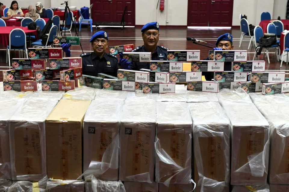 ANTARA BARANGAN DISITA: Komander Pasukan Polis Marin Wilayah Satu Pulau Pinang, ACP Shamsol Kassim (tengah), menunjukkan karton rokok yang dirampas pada sidang media di Batu Uban, Pulau Pinang.