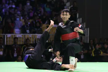 JUARA DUNIA BARU: Aniq (kanan) menjatuhkan lawan dari Malaysia, Mohammad Khairi Adib Azhar dalam pusingan akhir acara tanding B putera semalam. - Foto SIA KIAN TECK/PERSISI