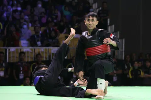 JUARA DUNIA BARU: Aniq (kanan) menjatuhkan lawan dari Malaysia, Mohammad Khairi Adib Azhar dalam pusingan akhir acara tanding B putera semalam. - Foto SIA KIAN TECK/PERSISI