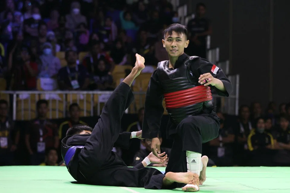 JUARA DUNIA BARU: Aniq (kanan) menjatuhkan lawan dari Malaysia, Mohammad Khairi Adib Azhar dalam pusingan akhir acara tanding B putera semalam. - Foto SIA KIAN TECK/PERSISI