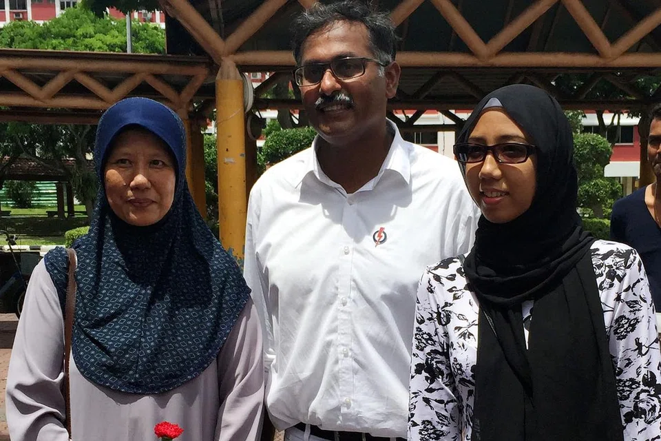 RASA BANGGA: Penduduk Bukit Batok selama hampir 31 tahun, Cik Suhaana Hasran (kiri) bersama anaknya, Cik Sakinah Ishaak, berasa gembira dengan kemenangan Encik Muralidharan Pillai daripada Parti Tindakan Rakyat dan ghairah hendak bergambar bersama Anggota Parlimen baru itu. Cik Suhaana memegang sekuntum bunga yang diberi Encik Murali kepada kaum ibu di kawasan kejiranan Bukit Batok Street 11 sempena Hari Ibu semalam, - Foto NURMAYA ALIAS 