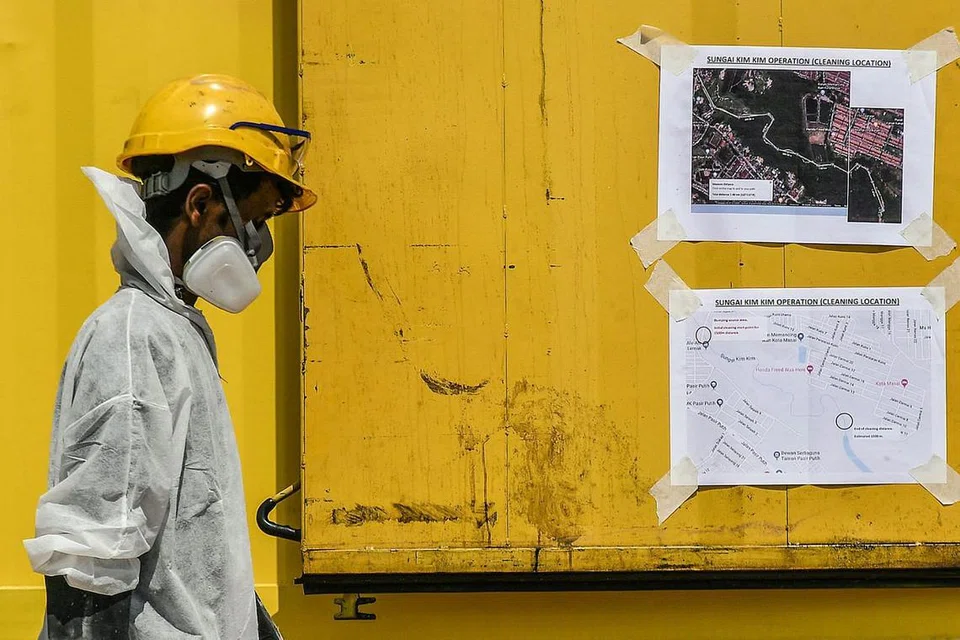 MASIH ADA LAGI TAPAK YANG TERCEMAR: Seorang kakitangan kecemasan dengan pakaian perlindungan di lokasi kerja pembersihanan di Sungai Kim Kim, Pasir Gudang. Pemeriksaan akhbar setempat menunjukkan ada tanda-tanda baru tapak pembuangan sisa lain dalam kawasan lima kilometer sungai itu. - Foto EPA-EFE