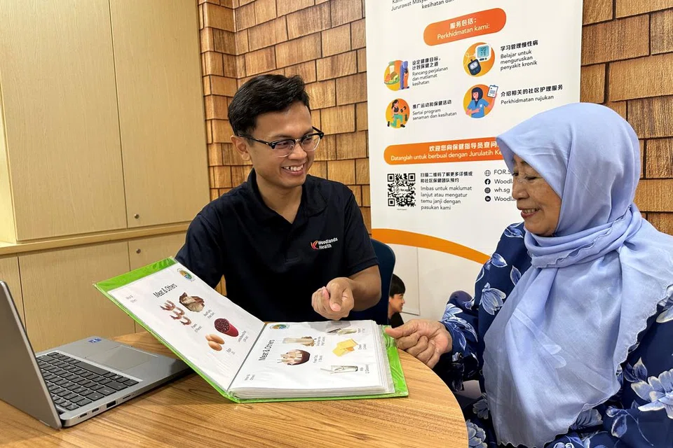 PENDIDIKAN MENYELURUH: Cik Fatimah Arib (kanan), 79 tahun, merupakan peserta aktif dalam program pencegahan dan pengurusan kelemahan dalam masyarakat, CommFit oleh Woodlands Health dan mendapat bimbingan daripada Encik Muhammad Haikal (kiri).