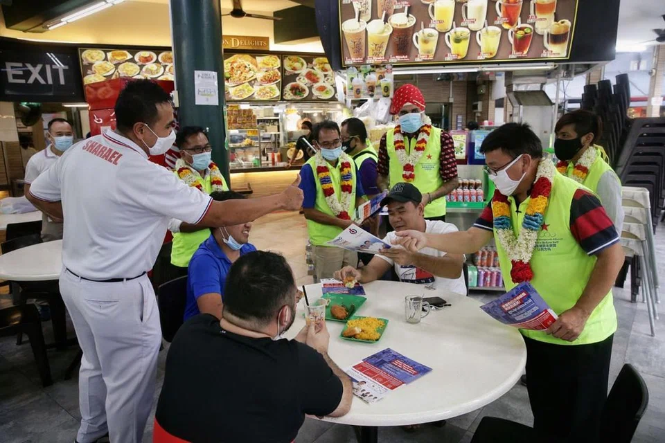 CALON PAP SHARAEL TAHA DAN PRESIDEN SDA DESMOND LIM BERTEMBUNG DI PASIR RIS - SAMA-SAMA PIKAT PENDUDUK: Calon Parti Tindakan Rakyat (PAP) di GRC Pasir Ris Punggol, Encik Mohamed Sharael Taha (baju-T putih, kiri) terserempak Presiden Perikatan Demokratik Singapura (SDA) Encik Desmond Lim Bak Chuan semasa bertemu penduduk di Elias Mall di Pasir Ris semalam. - Foto BH oleh KEVIN LIM