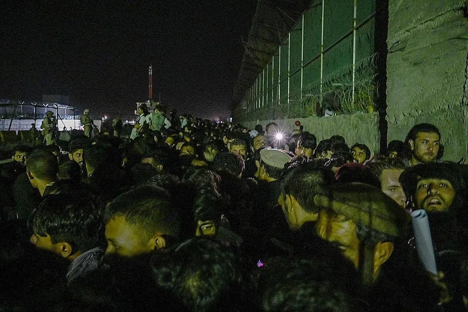 MASIH TUNGGU UNTUK TINGGALKAN NEGERI: Rakyat Afghanistan di luar bahagian lapangan terbang di Kabul yang dikawal tentera asing, menunggu hingga larut malam untuk keluar dari negara itu. - Foto AFP