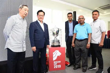 KEMBALI DIPERTANDINGKAN: (Dari kiri) Naib presiden FAS, Teo Hock Seng; presiden FAS, Lim Kia Tong; Setiausaha Agung FAS Yazeen Buhari; naib presiden FAS S. Thavaneson dan Razali Saad bergambar bersama trofi Piala Merlion yang bakal dipertandingkan Jun ini. - Foto FAS