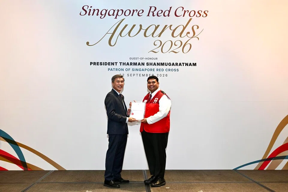 Encik Muhammad Zakir Abu Bakar (kanan) menerima Anugerah Penghargaan daripada Pengerusi Palang Merah Singapura (SRC), Encik Tan Kai Hoe, atas sumbangannya sebagai pembimbing belia SRC.