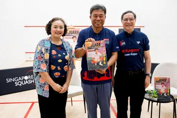 Penulis buku ‘Juara’, Rilla Melati Bahri, bergambar bersama legenda squash Singapura, Zainal Abidin Abdul Malik (tengah), dan presiden Persatuan Raket Squash Singapura, Patrick Thio, semasa pelancaran buku itu di Pusat Squash Kallang pada December 2024.