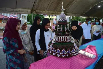 SEKTOR PELANCONGAN: Kerajaan Thailand meneroka laluan pelancongan halal di negara itu. Gambar dirakamkan pada 31 Oktober lalu menunjukkan sekumpulan wanita melihat secara dekat 'krathong' (bot lilin), sebagai sebahagian peraduan semasa pesta Loy Krathong di Narathiwat, selatan Thai. - Foto AFP