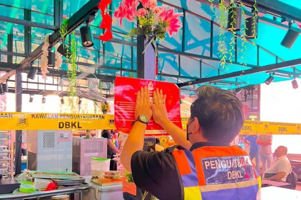 AMBIL TINDAKAN: Kakitangan Dewan Bandaraya Kuala Lumpur (DBKL) menampal notis penutupan sebuah premis perniagaan yang menyalahi undang-undang dan beroperasi tanpa lesen diusahakan warga asing di pusat bandar Kuala Lumpur. 