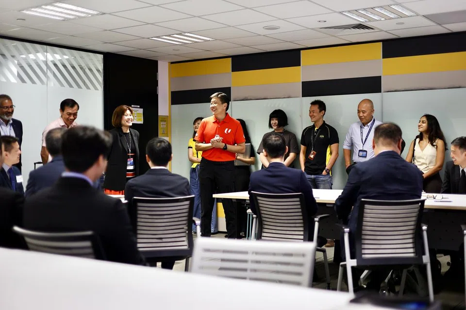 Setiausaha Agung Kongres Kesatuan Sekerja Kebangsaan (NTUC), Encik Ng Chee Meng (berbaju merah), bertemu dengan kakitangan Jetstar Asia di Terminal 1 Lapangan Terbang Changi semasa acara khidmat pemadanan pekerjaan yang dianjurkan untuk mereka pada 18 Jun.