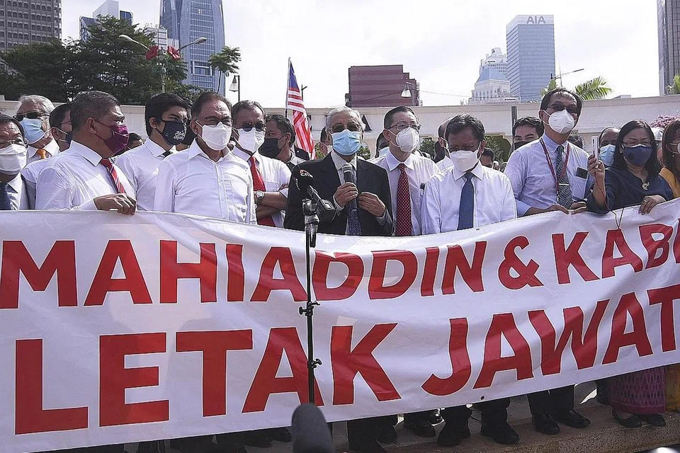 SUARA PEMIMPIN: Mantan Perdana Menteri Malaysia, Tun Dr Mahathir Mohamad (tengah) dan Ketua Pembangkang, Datuk Seri Anwar Ibrahim (tiga dari kiri), yang juga mantan Timbalan Perdana Menteri, berucap di depan pihak media sebagai membantah penutupan Parlimen di Dataran Merdeka, Kuala Lumpur, semalam. Nama Mahiaddin yang tertera pada sepanduk adalah nama yang didaftarkan dalam sijil lahir Tan Sri Muhyiddin. - Foto AFP