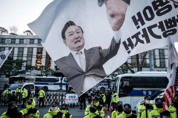 Sebuah bendera yang memaparkan wajah Presiden Korea Selatan, Yoon Suk Yeol, yang sedang berdepan proses pemecatan, dikibarkan oleh penyokongnya semasa satu perhimpunan di hadapan Mahkamah Perlembagaan di Seoul pada 19 Mac 2025. Perhimpunan itu diadakan menjelang keputusan akhir pemecatan Presiden.
