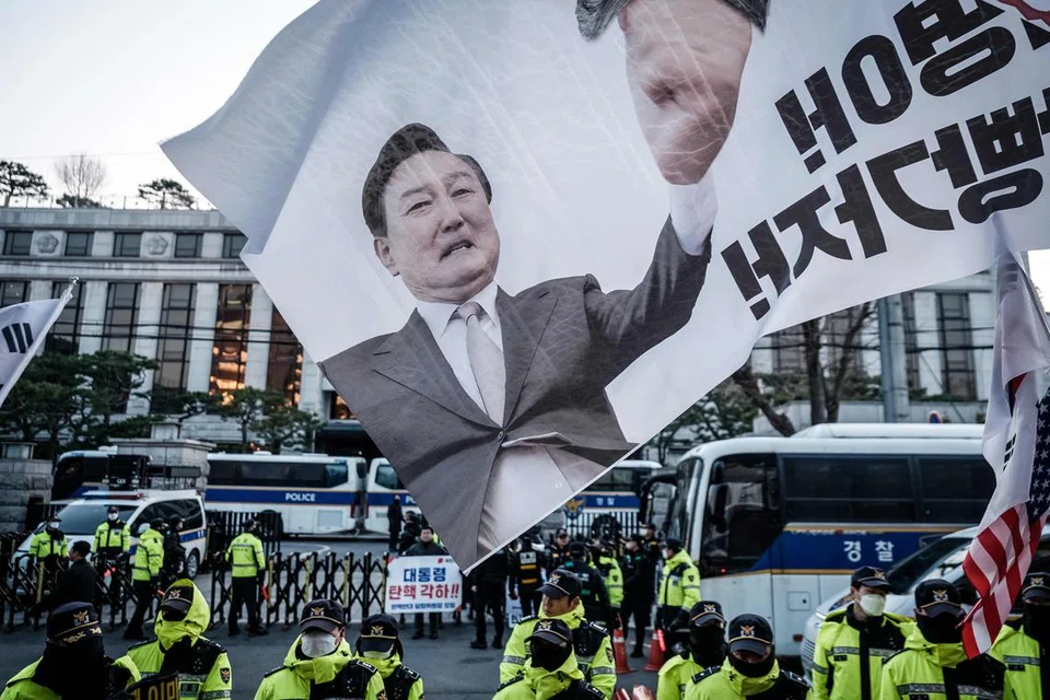 Sebuah bendera yang memaparkan wajah Presiden Korea Selatan, Yoon Suk Yeol, yang sedang berdepan proses pemecatan, dikibarkan oleh penyokongnya semasa satu perhimpunan di hadapan Mahkamah Perlembagaan di Seoul pada 19 Mac 2025. Perhimpunan itu diadakan menjelang keputusan akhir pemecatan Presiden.