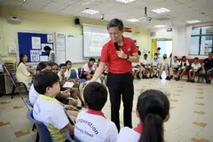 RAI KEHARMONIAN KAUM: Encik Chan Chun Sing (berbaju merah) menyertai murid Darjah 6 di Sekolah Rendah Corporation, Jurong West, dalam kelas Pendidikan Perwatakan dan Kewarganegaraan (CCE) untuk membincangkan isu stereotaip kaum.