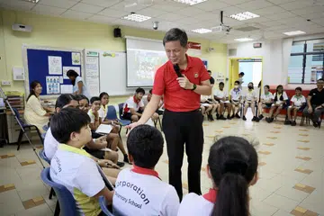 RAI KEHARMONIAN KAUM: Encik Chan Chun Sing (berbaju merah) menyertai murid Darjah 6 di Sekolah Rendah Corporation, Jurong West, dalam kelas Pendidikan Perwatakan dan Kewarganegaraan (CCE) untuk membincangkan isu stereotaip kaum.