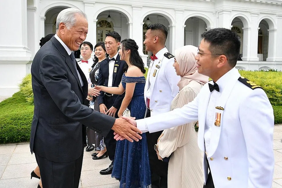BERJABAT TANGAN: Dr Ng (kiri) berinteraksi dengan lulusan terbaik bersama pasangan mereka di Kolej Komand dan Staf Goh Keng Swee kelmarin. - Foto MINDEF