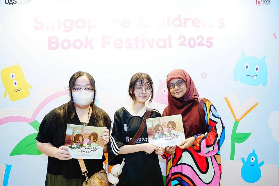 Pelajar Akademi Seni Halus Nanyang (Nafa), Cik Leow Jiayee (kiri) dan Cik Elly Sabrina Arun (dua dari kiri), bersama penyunting buku ‘Nasi Lemak Emak’, Cik Nur-El-Hudaa Jaafar di Festival Buku Kanak-Kanak di Nafa.