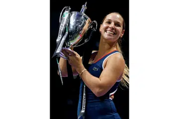 UNGGUL: Pemain Slovakia, Dominika Cibulkova, menjulang trofi kejuaraan Final WTA dalam penampilan sulungnya di kejohanan berprestij ini. Beliau mengalahkan pemain nombor satu dunia, Angelique Kerber, 6-3, 6-4. - Foto REUTERS
