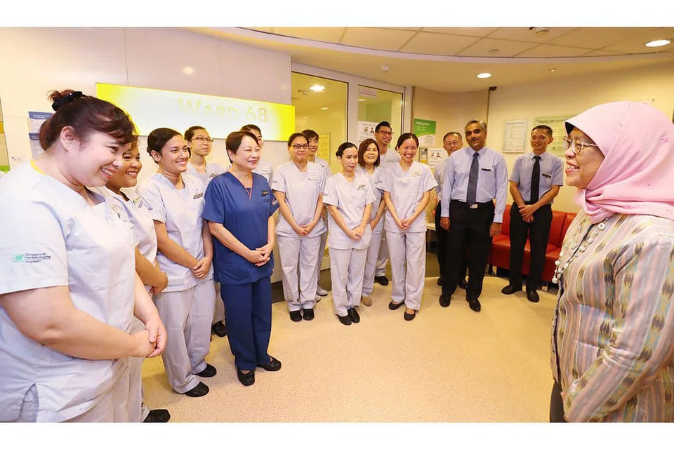 BERI SOKONGAN KEPADA PEKERJA KESIHATAN: Presiden Halimah menziarahi Pasukan Wad Pengasingan, Hospital Besar Singapura (SGH) di kawasan menunggu baru-baru ini. - Foto fail