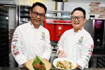 Presiden SHCF, Cef Muhammad Kamal Khamis (kiri) memasak hidangan rendang daging yang lebih berkhasiat dan Naib Presiden SHCF, Cef Muhammad Imran Sani, yang menampilkan hidangan salad kuinoa, avokado dan ayam serta jeruk tomato bakar. 